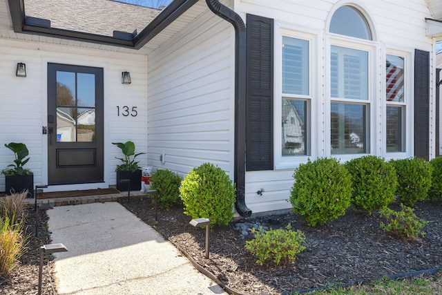 property entrance featuring roof with shingles