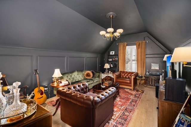 interior space featuring vaulted ceiling, a decorative wall, wood finished floors, and a chandelier