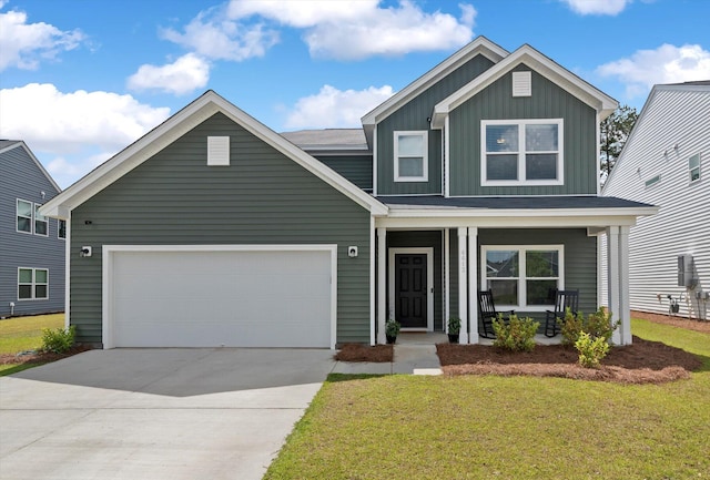 view of front of home featuring a front yard, a porch, and a garage