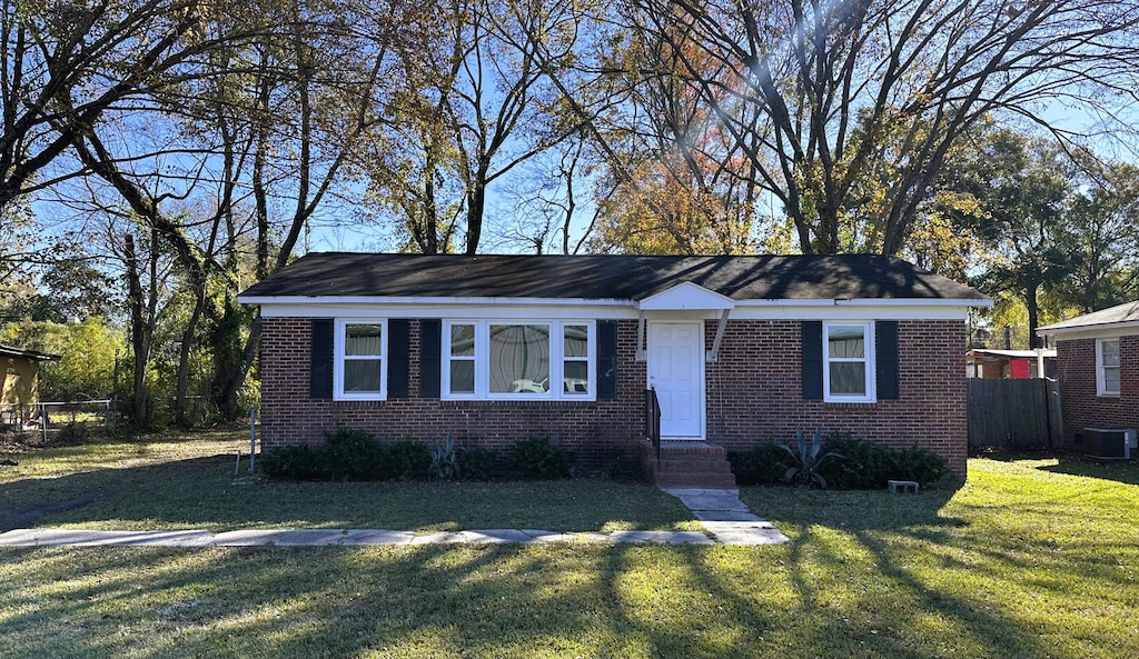 8 Eucalyptus Ave, North Charleston, SC 29418 - ranch-style home featuring central AC unit, fence, a front lawn, entry steps, and brick siding