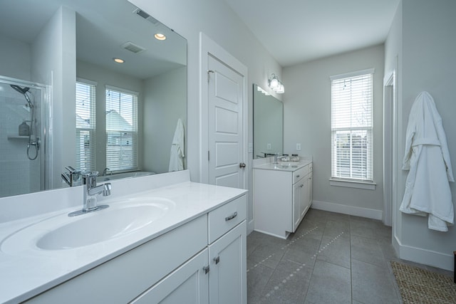 full bathroom featuring a stall shower, baseboards, a sink, tile patterned flooring, and two vanities