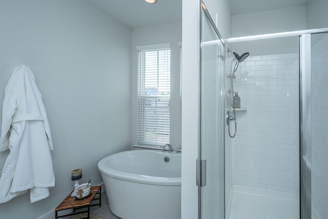 bathroom featuring a freestanding tub and a shower stall