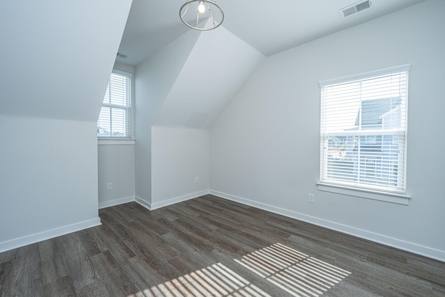 bonus room featuring lofted ceiling, baseboards, visible vents, and dark wood finished floors