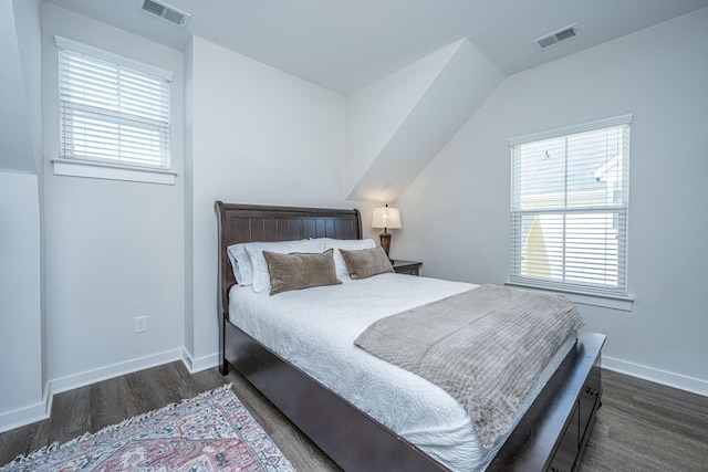 bedroom with multiple windows, wood finished floors, visible vents, and baseboards