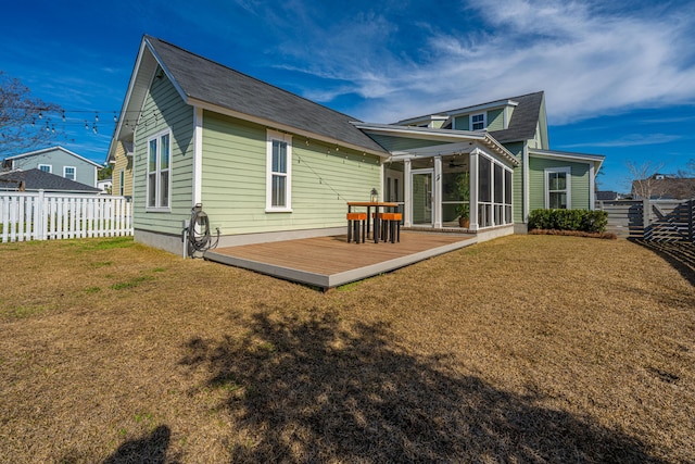 rear view of house with a sunroom, a fenced backyard, a lawn, and a wooden deck