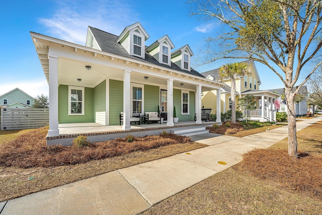 view of front of home featuring covered porch and fence