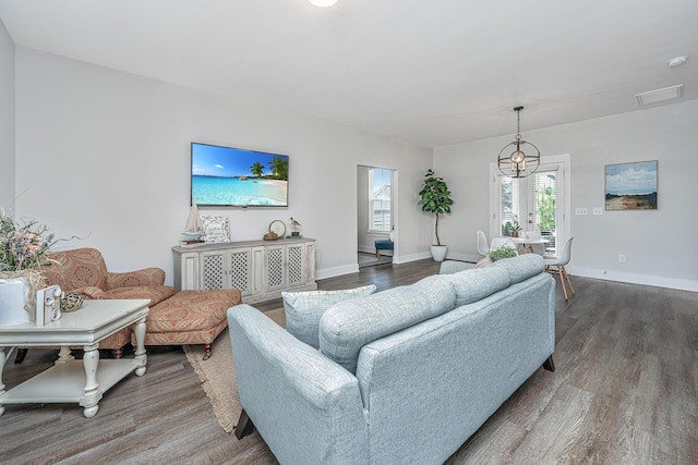 living area with wood finished floors, visible vents, and baseboards