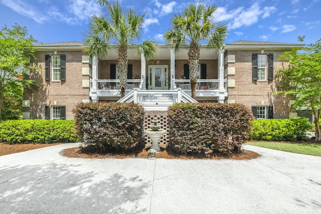 view of front of home featuring stairway and brick siding