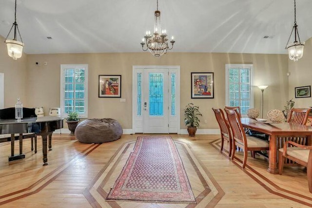 entryway featuring a chandelier, visible vents, light wood-style flooring, and baseboards