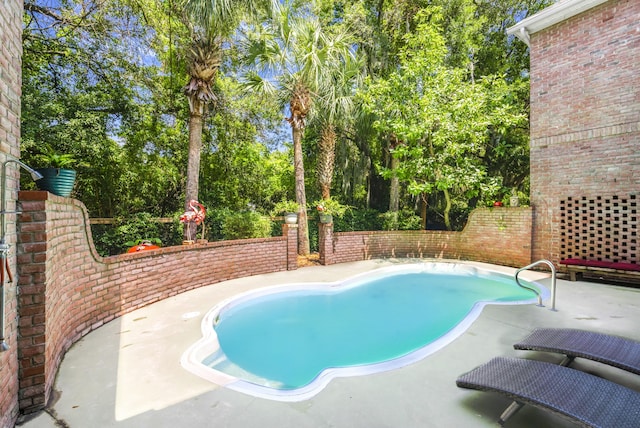 outdoor pool with a patio area and fence