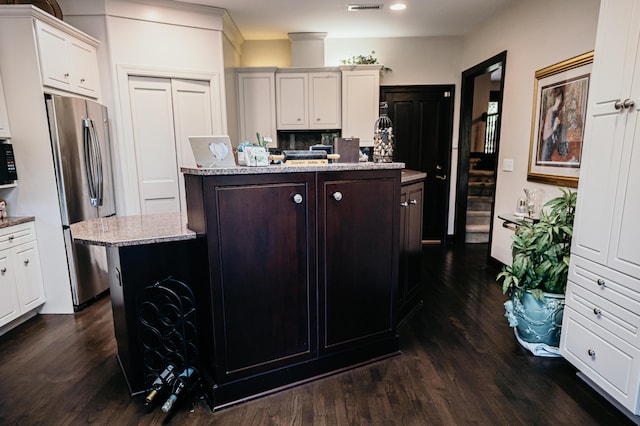 2860 Old Drake Dr, Johns Island, SC 29455 - kitchen with stainless steel refrigerator, light stone counters, dark hardwood / wood-style flooring, an island with sink, and white cabinets