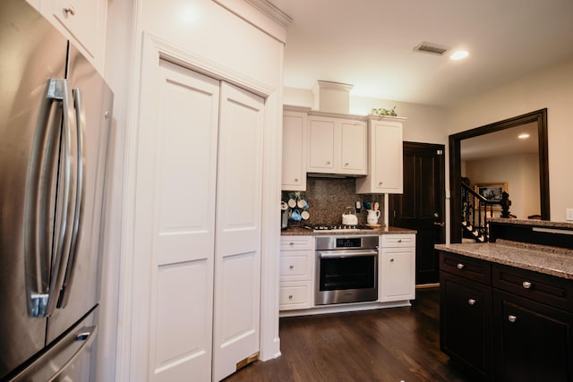 2860 Old Drake Dr, Johns Island, SC 29455 - kitchen with light stone countertops, appliances with stainless steel finishes, dark hardwood / wood-style flooring, and backsplash