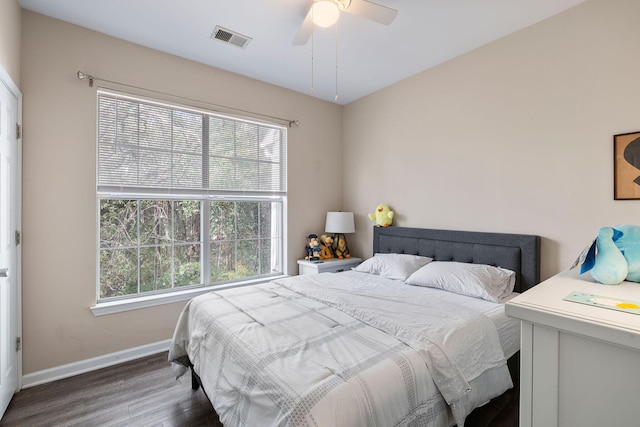 bedroom featuring baseboards, visible vents, a ceiling fan, and wood finished floors