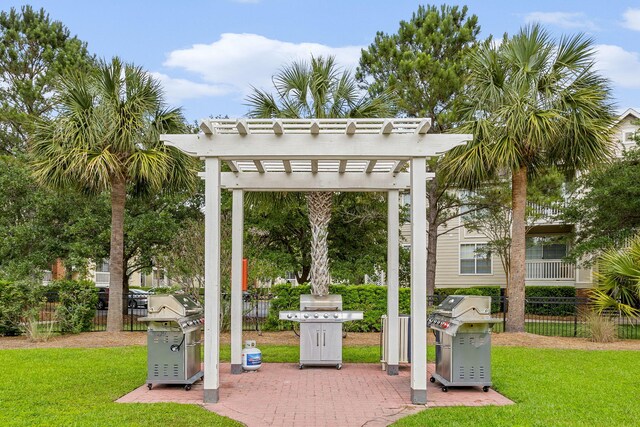 view of community featuring a pergola, fence, and a lawn