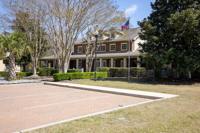 view of front of property with uncovered parking and a front lawn