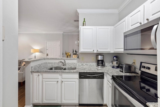 kitchen with crown molding, a sink, appliances with stainless steel finishes, a peninsula, and white cabinets