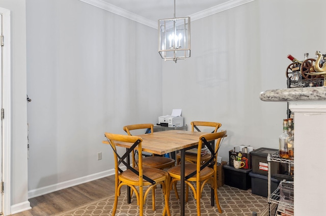dining room with baseboards, dark wood-style flooring, ornamental molding, and a chandelier