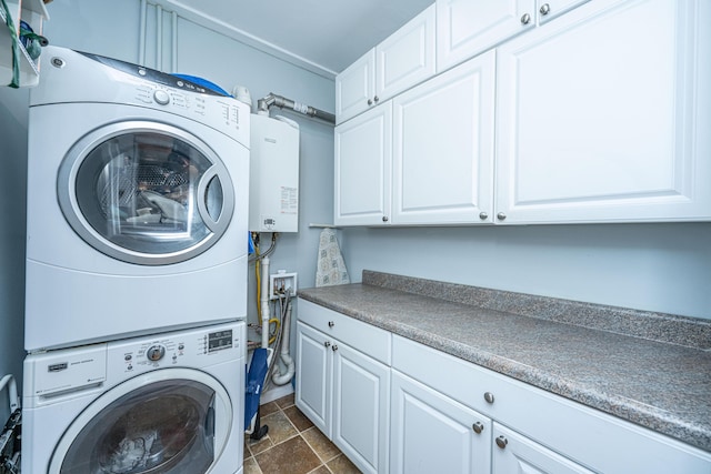 802 Robert E Lee Blvd, Charleston, SC 29412 - washroom featuring stacked washer / drying machine, cabinet space, tankless water heater, and dark stone finish flooring