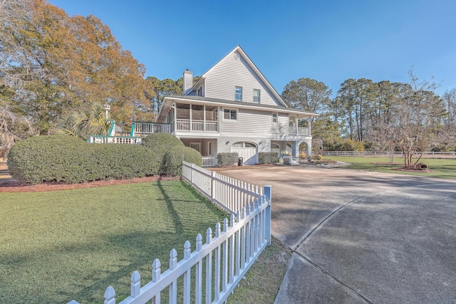 rear view of property with a yard and a sunroom