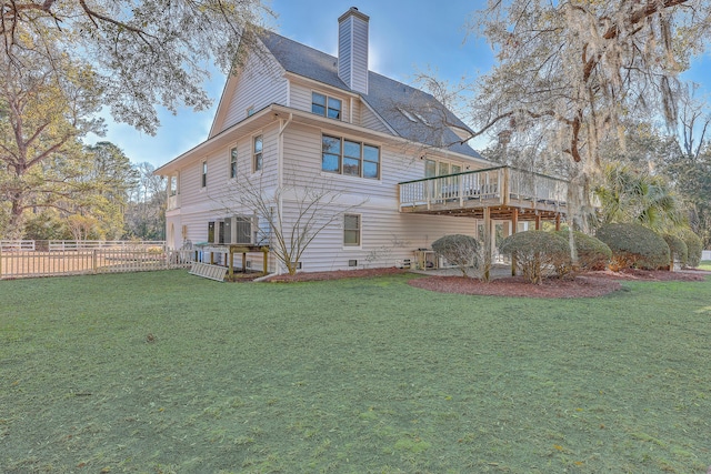 back of property with a wooden deck and a yard