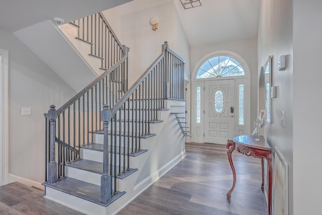 entrance foyer featuring vaulted ceiling and dark hardwood / wood-style flooring