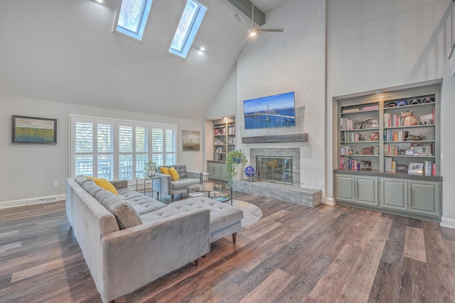 living room featuring dark wood-type flooring, built in features, a skylight, high vaulted ceiling, and a brick fireplace