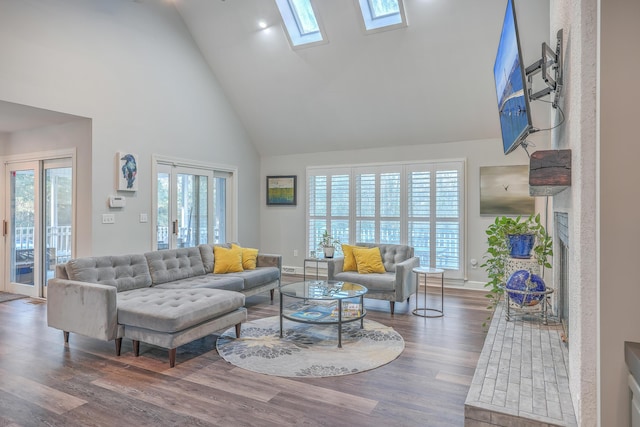 living room featuring dark hardwood / wood-style flooring, a skylight, and high vaulted ceiling