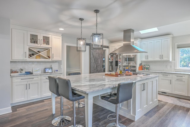 kitchen featuring island exhaust hood, a barn door, and white cabinets