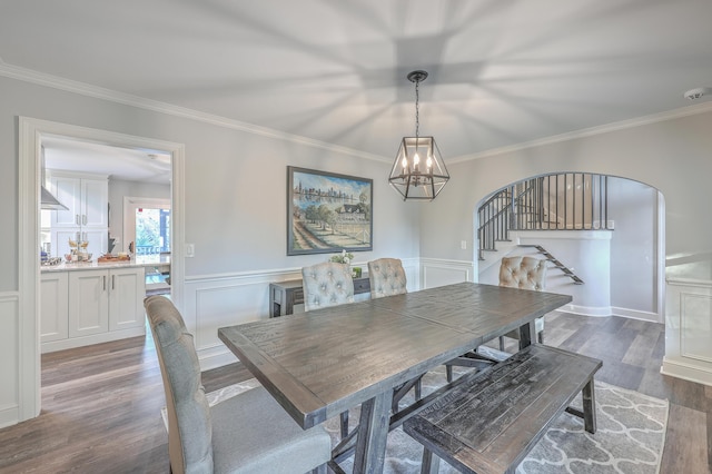 dining space featuring an inviting chandelier, ornamental molding, and dark hardwood / wood-style floors