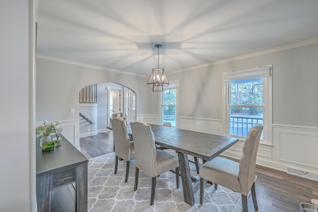 dining space with an inviting chandelier, crown molding, and hardwood / wood-style flooring