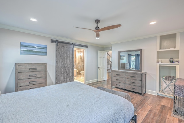 bedroom with dark hardwood / wood-style floors, ceiling fan, crown molding, a barn door, and ensuite bath