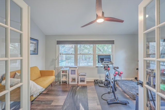 exercise area featuring vaulted ceiling, dark wood-type flooring, ceiling fan, and french doors