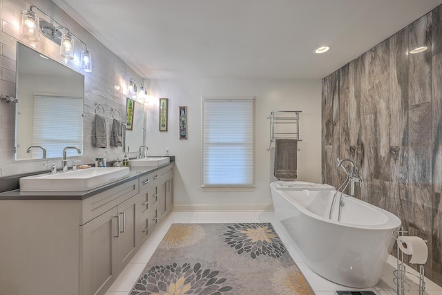 bathroom with tile patterned flooring, vanity, a tub, and tile walls