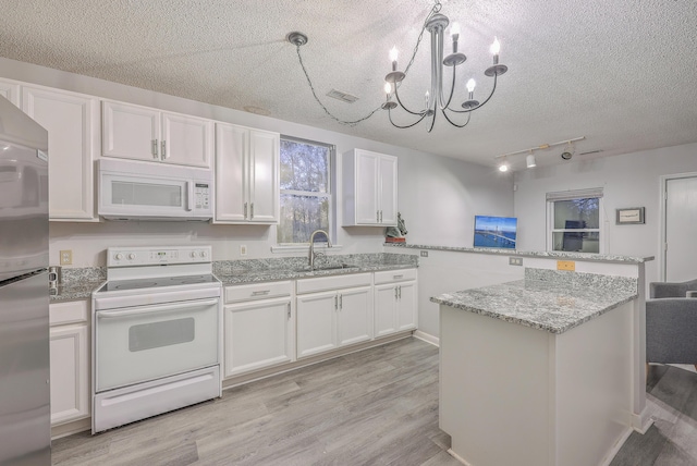 kitchen featuring sink, white cabinets, white appliances, and decorative light fixtures