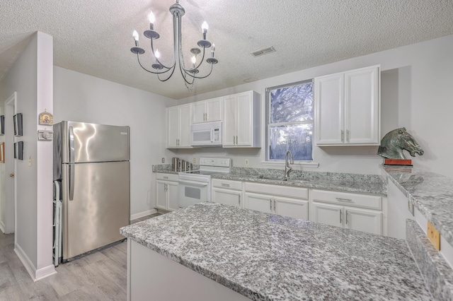 kitchen featuring sink, a textured ceiling, white appliances, light hardwood / wood-style floors, and white cabinets