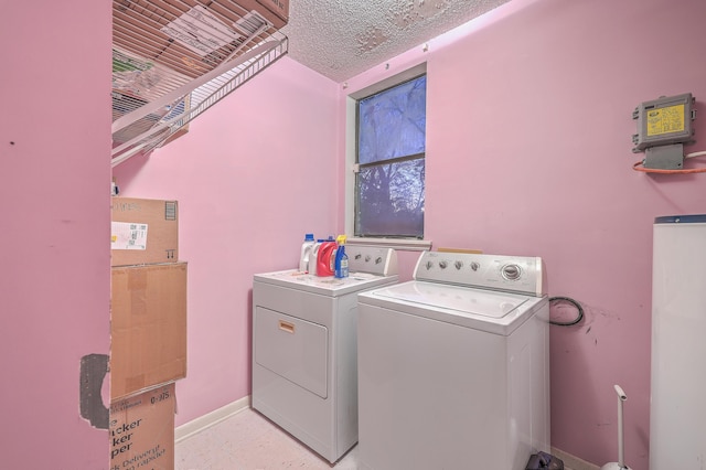 clothes washing area featuring washing machine and dryer and a textured ceiling