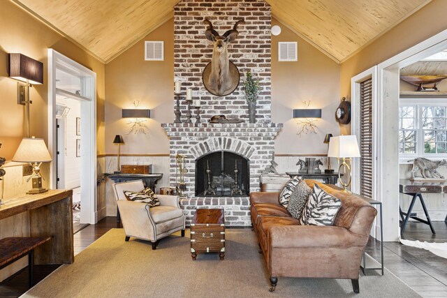living area with wood ceiling, visible vents, and a fireplace