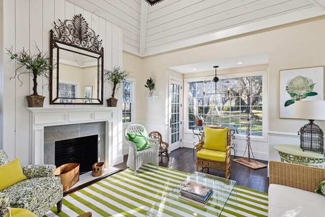 living area with a fireplace with flush hearth, plenty of natural light, and wood finished floors