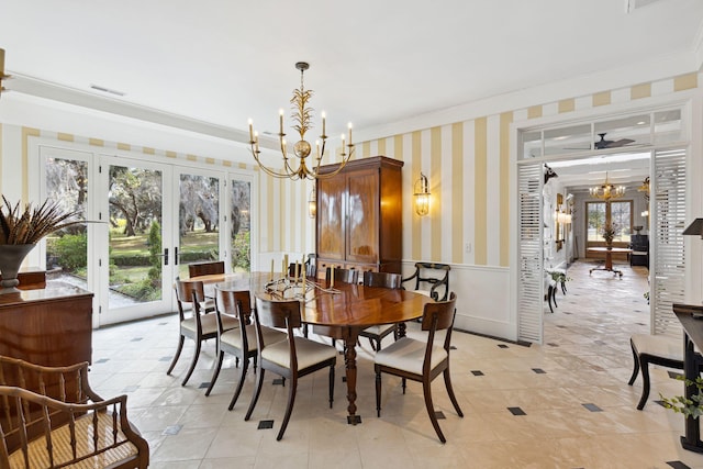 dining room with wallpapered walls, visible vents, ornamental molding, wainscoting, and a notable chandelier