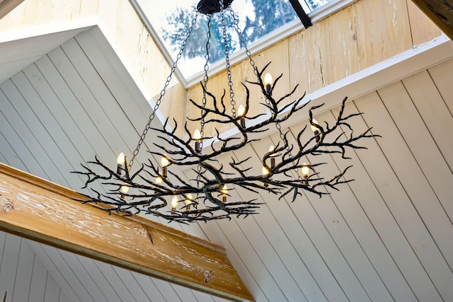 details featuring wood walls and an inviting chandelier