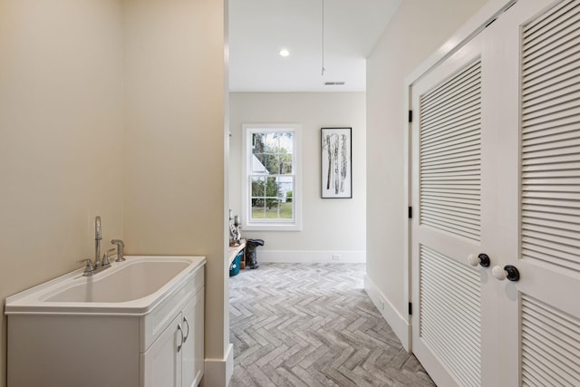 laundry area with visible vents, attic access, baseboards, and recessed lighting