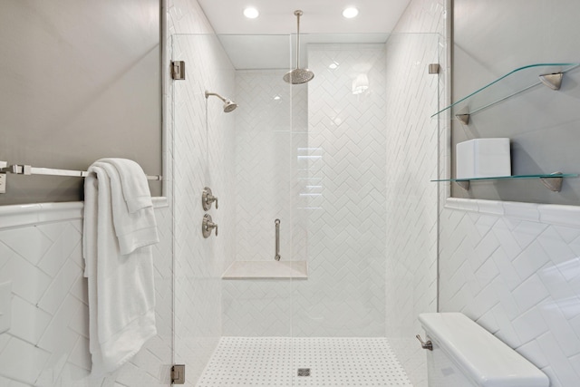 bathroom featuring wainscoting, recessed lighting, a stall shower, and tile walls