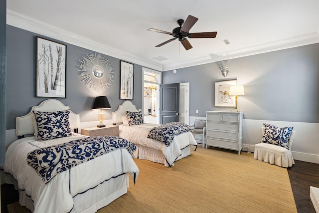 bedroom with baseboards, crown molding, wood finished floors, and visible vents