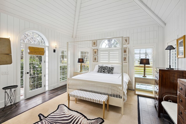 bedroom featuring high vaulted ceiling, access to outside, wood finished floors, and wooden walls