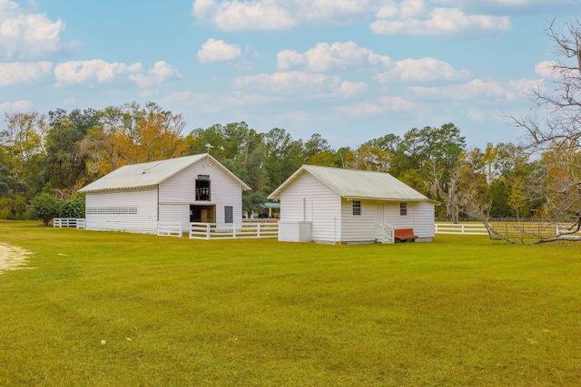 view of yard featuring an outdoor structure, fence, and a barn