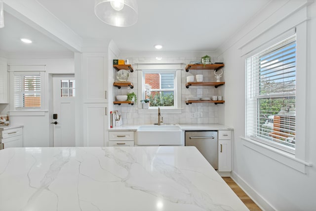 kitchen with white cabinets, sink, stainless steel dishwasher, decorative backsplash, and light stone countertops