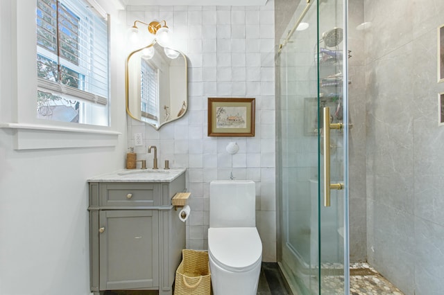 bathroom with vanity, toilet, walk in shower, and tile walls