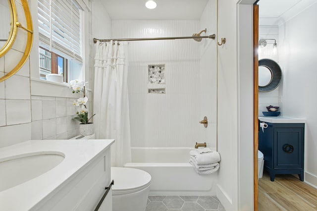 full bathroom with shower / bath combo, toilet, tile walls, and vanity