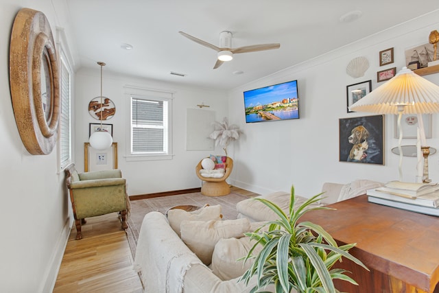 living room featuring ceiling fan, light wood-type flooring, and ornamental molding