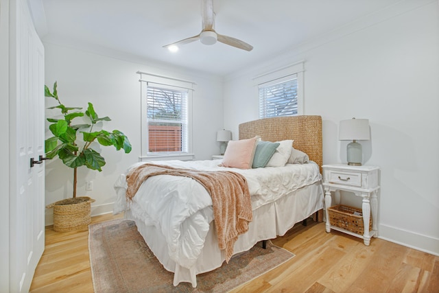 bedroom featuring ceiling fan, ornamental molding, and light wood-type flooring